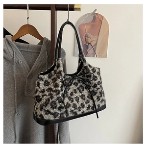 Close-up of leopard print faux fur tote bag with black leather handles and bow detail
