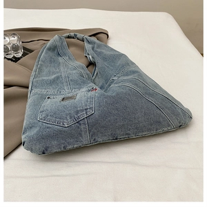 Vue détaillée du sac en jean délavé avec coutures rouges et étiquette logo BDK en métal