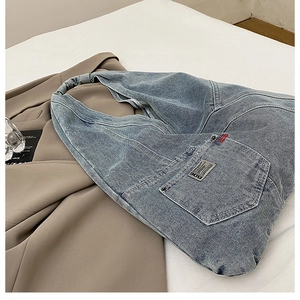 Vue détaillée de la texture denim avec logo métallique BDG sur un sac cabas bleu clair