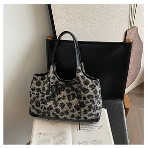 Detail of grey leopard print plush tote bag with black leather bow and handle