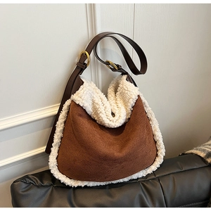 Détail du sac cabas en daim marron avec bordure en peau lainée et boucle dorée