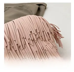Macro shot of pink leather fringe texture and craftsmanship on a stylish crossbody bag