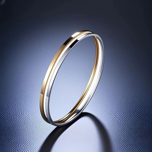 Macro view of interlocking gold and silver stainless steel bangles with mirror finish