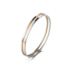 Polished gold and silver interlocking stainless steel bangle with a sleek buckle closure