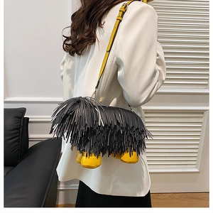 Detail view of funny puppy crossbody bag with black long fringe and yellow leather straps