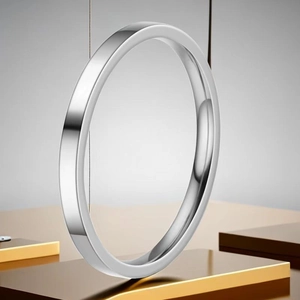 Polished silver stainless steel minimalist ring reflecting on a sleek mirrored surface