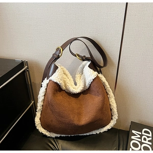 Détail du sac hobo en daim marron avec bordure en peau de mouton blanche et anneau doré