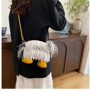Detail view of a creative puppy-shaped crossbody bag featuring black and white long tassels