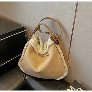 Détail du sac hobo en daim camel avec bordure en fausse fourrure blanche et boucle en laiton