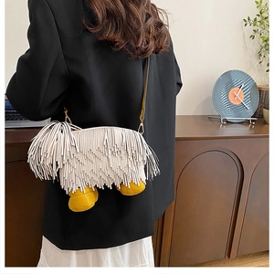 Detail of creative dog-shaped shoulder bag with white leather fringe and long hair texture