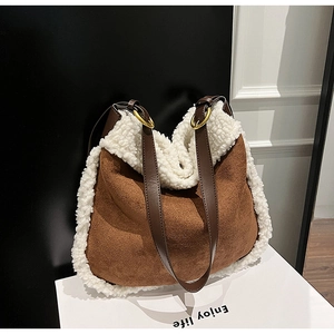 Détail de la bordure en faux mouton sur sac bandoulière en daim brun et anneaux dorés