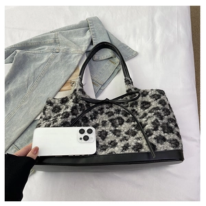 Plush leopard print tote bag detail showing large capacity compared to a smartphone