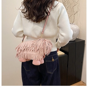 Detail of pink tassel crossbody bag shaped like a puppy with elegant gold metal hooks