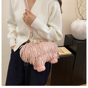 Close-up of creative pink tassel puppy crossbody bag with gold metal buckle details