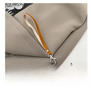 Close-up of orange leather hand strap with premium silver metal lobster clasp detail