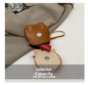 Detail view of the mini brown owl coin purse showing internal capacity for a lipstick