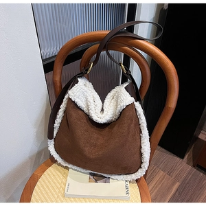 Gros plan détaillé du sac à bandoulière en daim marron avec bordure en fausse fourrure