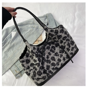Close-up of leopard print plush tote bag with black leather handles and bow detail
