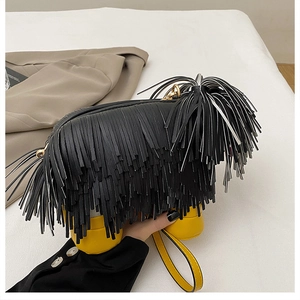 Macro detail of unique dog-shaped crossbody bag featuring black fringe and yellow legs