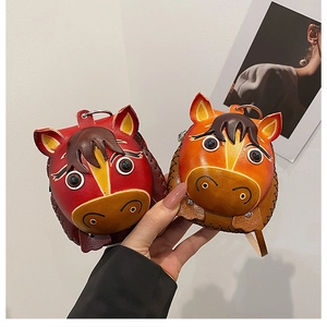 Close-up of handmade leather horse head coin purses with visible thick stitching detail