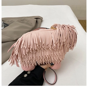 Detailed shot of pink fringe dog-shaped crossbody bag with gold zipper and leather strap