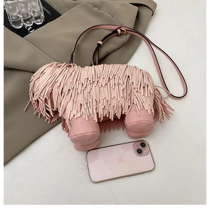 Detail of pink tassel dog-shaped crossbody bag on grey blazer with phone for scale