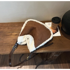 Détail du sac en daim avec bordure en similicuir mouton et bandoulière en cuir réglable