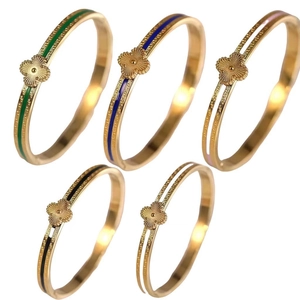 Gold plated stainless steel clover bangles set with Greek key patterns and enamel inlays