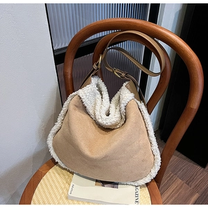Détail d'un sac à bandoulière en suède avec bordure en peau de mouton sur chaise