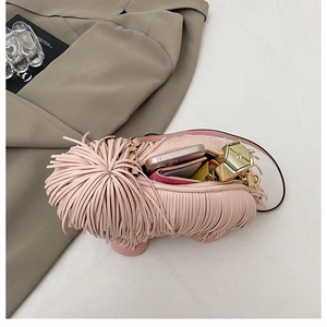 Pink fringed dog-shaped crossbody bag showing internal capacity for phone and lipstick