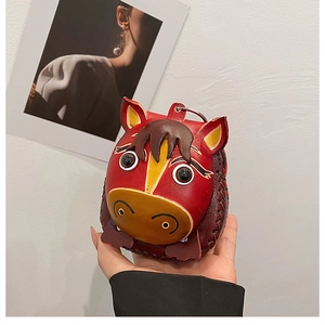 Close-up of handmade red leather horse-shaped coin purse with detailed stitching