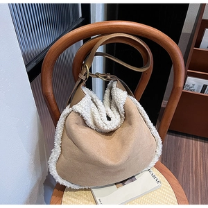 Détail du sac à bandoulière en daim marron avec bordure en polaire blanche et anneaux en métal