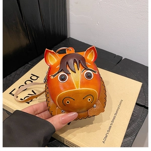 Close-up of a handmade orange leather horse-shaped coin purse with detailed stitching