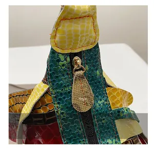Detail of colorful patchwork embossed leather bag with smooth golden metal zipper closure
