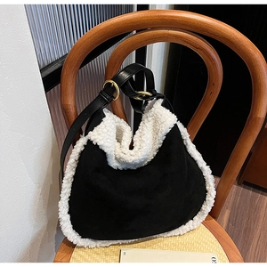 Détail du sac à bandoulière en daim noir avec bordure en fausse fourrure blanche et boucle