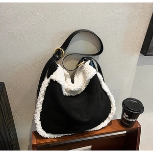 Detail of hobo bag with black canvas and white faux fur texture with gold buckle