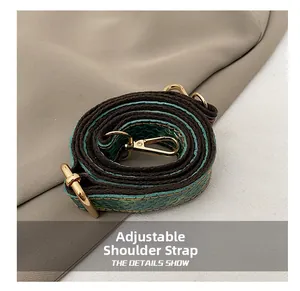 Detail of adjustable bag strap with blue fish-scale embossed leather and gold hooks