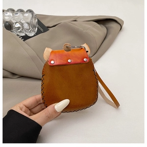 Detail of vintage leather mini coin purse with gradient flap and metal rivets held by hand
