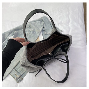 Detail view of the large plush tote bag showing striped lining and magnetic closure
