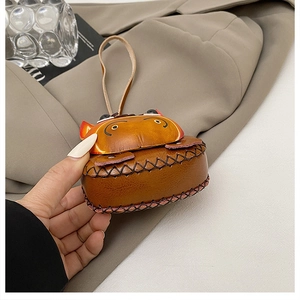 Detailed view of handmade brown leather hippo mini pouch with distinct cross-stitching