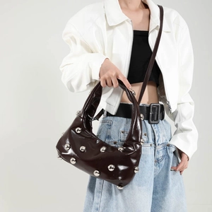 Dark brown patent leather dumpling bag with silver studs and adjustable shoulder strap