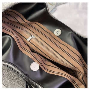 Detail view of plush bag interior showing striped lining and magnetic snap closure