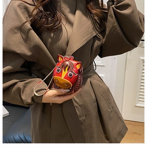 Detailed close-up of a red horse-shaped leather mini bag with yellow strap details