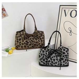 Detail of leopard print plush tote bags with soft faux fur texture and bow accents