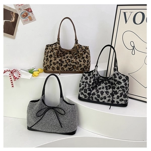 Detailed view of plush leopard print tote bags with faux leather bows and straps