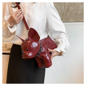 Detail of burgundy bulldog shaped crossbody bag featuring a studded collar and glossy finish