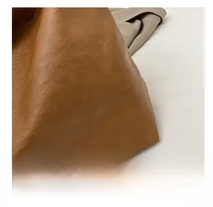 Detail shot of brown lychee-patterned soft leather material for travel tote bag