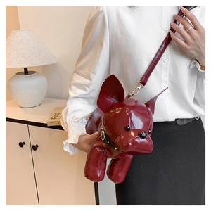 Close-up of a glossy wine red French bulldog shaped crossbody bag with black collar detail