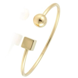 Polished gold cuff bracelet featuring minimalist sphere and geometric cube ends