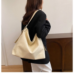 Cream white large capacity tote bag shown on shoulder in minimalist interior setting